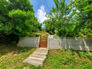 een hek met een hek en een trap in een tuin bij Beehives in Koetaisi