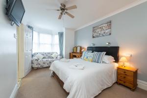 韦茅斯The Pebbles - Adults Only的带一张大床和一张沙发的卧室