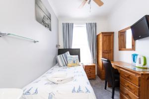 - une chambre avec un lit et un bureau dans l'établissement The Pebbles - Adults Only, à Weymouth