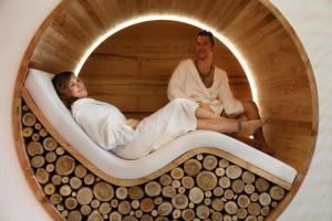 Un uomo e una donna seduti in una sauna di Hotel Gardenia a Passo del Tonale