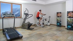 a man riding an exercise bike in a gym at Hotel Gardenia in Passo del Tonale