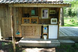 ein kleines Holzgebäude mit einem Kühlschrank und einer Theke in der Unterkunft Karlsäter - Lilla stugan in Älvkarleby