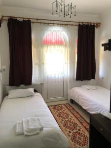 a bedroom with two beds and a window and a chandelier at Cappadocia Kepez hotel in Goreme