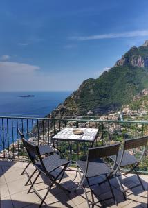- stół i krzesła na balkonie z widokiem na ocean w obiekcie Casa TerryB - il Monticello w mieście Positano