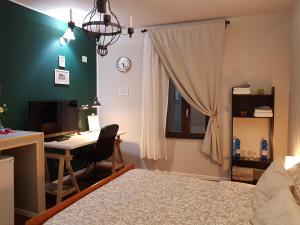 Schlafzimmer mit einem Bett und einem Schreibtisch mit einem Computer in der Unterkunft Palazzo Adalgisa in Borgoforte