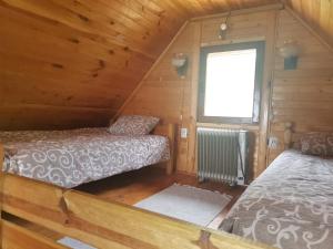 a room with two beds in a wooden cabin at Careva voda 1 in Dobroselica
