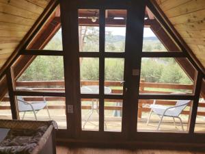 a large window in a cabin with a table and chairs at Careva voda 1 in Dobroselica