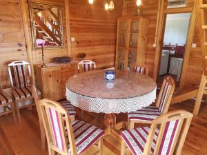 a dining room with a table and chairs in a cabin at Careva voda 1 in Dobroselica