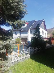 a white house with a fence in front of it at Penzion Pohoda - apartmány in Jeseník