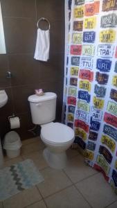 a bathroom with a toilet and a wall of drinks at Hostal Los Castaños in Viña del Mar