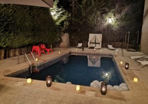 a swimming pool at night with candles in it at Hotel Prado Real in Soto del Real