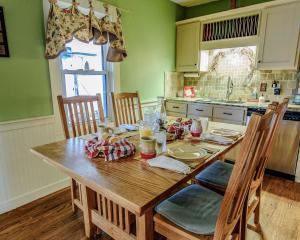 een keuken met een houten tafel met stoelen en een tafel bij Wolf Creek Farm B&B and Motorcycle Manor at Wolf Creek Farm, LLC in Ararat