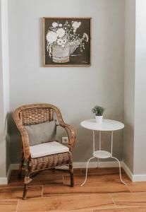 a wicker chair and a table in a room with a picture at Quinta Costa da Estrela in Gouveia