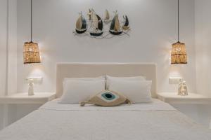 a white bedroom with a bed with a basket on it at Villa Agape in Naxos Chora
