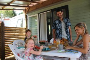 Un groupe de personnes assises autour d'une table dans l'établissement Domaine Sainte Veziane, à Bessan