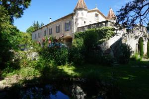an old building with a pond in front of it at Les Deux Tours in Brignon