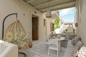 a patio with a couch and a table and chairs at Villa Agape in Naxos Chora