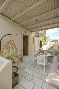 a patio with a table and chairs and a ceiling at Villa Agape in Naxos Chora