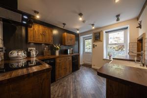 a large kitchen with wooden cabinets and a sink at The Lodge in the Loch in Portree