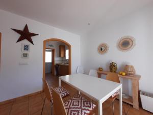 een eetkamer met een witte tafel en stoelen bij Villa con piscina privada in Calpe