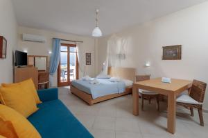 1 dormitorio con cama, mesa y sofá en Margaritari Hotel en Agia Anna Naxos