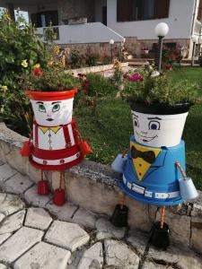 dois potes coloridos de flores num quintal em Da Mario & Marianna em Campanedda