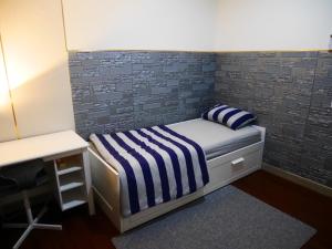 a small bedroom with a bed and a desk at Fairview House apartment karawaci in Karawaci