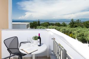 uma varanda branca com uma mesa e copos de vinho em Louloudis Boutique Hotel em Skala Rachoniou