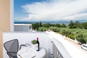 balcone con tavolo, sedie e vista sull'oceano di Louloudis Boutique Hotel a Skala Rachoniou