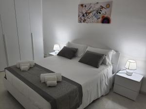 een witte slaapkamer met een groot bed met 2 nachtkastjes bij Appartamento MariaLuisa in Marsala