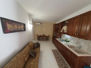 Appartamento MariaLuisa في مارسالا: غرفة معيشة مع أريكة ومطبخ
