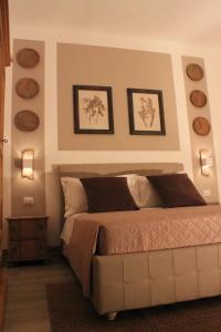 レッチェにあるDomus Albertaのベッドルーム1室(ベッド1台、壁に4皿のベッドプレート付)