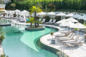 a swimming pool with lounge chairs and umbrellas at Siena Premium Retreat in Lozenets