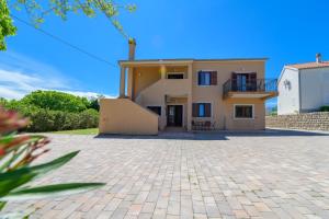 una casa grande con una entrada de ladrillo delante de ella en Apartments Marina Veskovic, en Nerezine