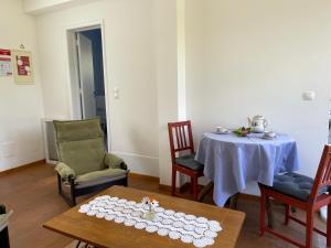 a dining room with a table and chairs and a table sidx sidx sidx at Quinta dos Sabores Farm Houses in Ribeira Grande
