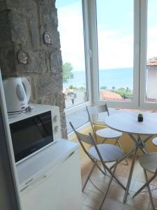 a kitchen with a tv and a table and chairs at Kyshta za Gosti Dari Rumi 1 in Sozopol