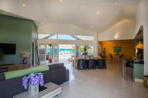 een woonkamer met een bank en een tafel met paarse bloemen bij Villa Curazon met privézwembad vlakbij het strand! in Jan Thiel