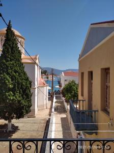 een straat in een stad met een boom op de stoep bij Paradisos Kastellorizou in Meyisti