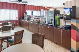 a restaurant with a counter and tables and chairs at Quality Inn & Suites in Mankato