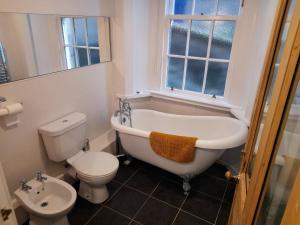 a bathroom with a tub and a toilet and a sink at Burntisland Garden Apartment, Fife - 40 mins to Edinburgh in Burntisland
