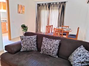 un divano marrone con cuscini in soggiorno di ACV - Isla Park-1ª Linea Planta 9 Frontal Interior a Oropesa del Mar