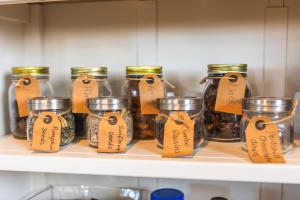 a shelf full of jars with tags on them at The Royson Guest House in Shanklin