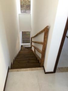 eine Holztreppe in einem Zimmer mit Fenster in der Unterkunft Casa duplex de temporada em Imbassai in Imbassai