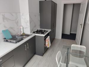 a small kitchen with a stove and a sink at Sleep Well in Poznań