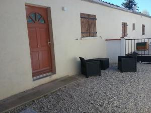 eine rote Tür und zwei Stühle vor einem Gebäude in der Unterkunft Rêve de Bulles T3=62m2 in Châlons-en-Champagne