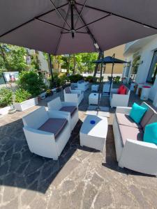 a group of chairs and an umbrella on a patio at Hotel Senza Pensieri Riccione in Riccione