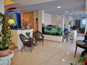 ein Wohnzimmer mit einem Aquarium und Stühlen in der Unterkunft Hotel Il Gatto in Rapallo
