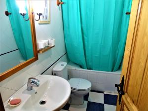W łazience znajduje się umywalka i toaleta z niebieską zasłoną prysznicową. w obiekcie Hostal Camino Del Cid w mieście Huerta del Rey