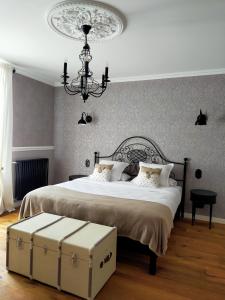 sypialnia z dużym łóżkiem i żyrandolem w obiekcie La Belle Epoque w mieście Kerlaz