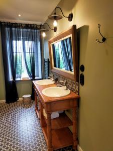 a bathroom with a wooden sink and a mirror at La Belle Epoque in Kerlaz